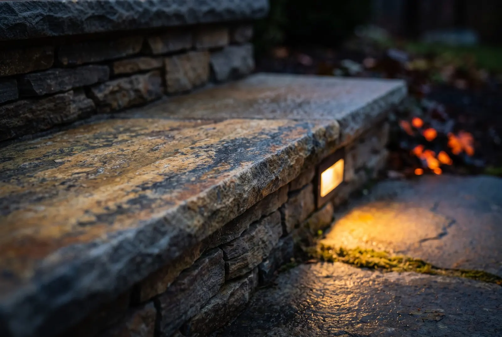 Nahdetail einer Flagstone-Trittstufe über einer Naturstein-Setzstufe mit warmer Beleuchtung in der Dämmerung